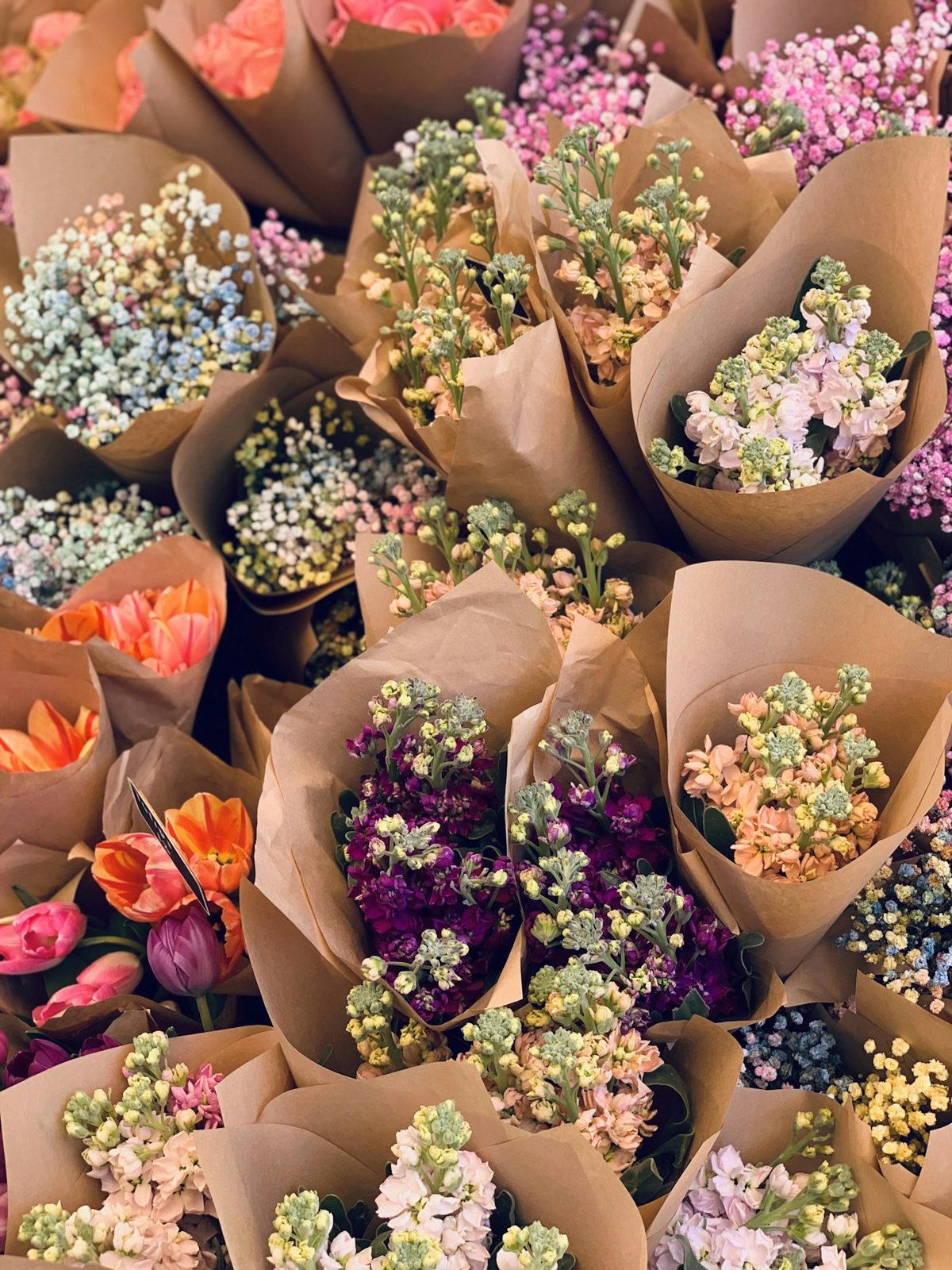 Buquês de flores avulsas embrulhados em papel kraft